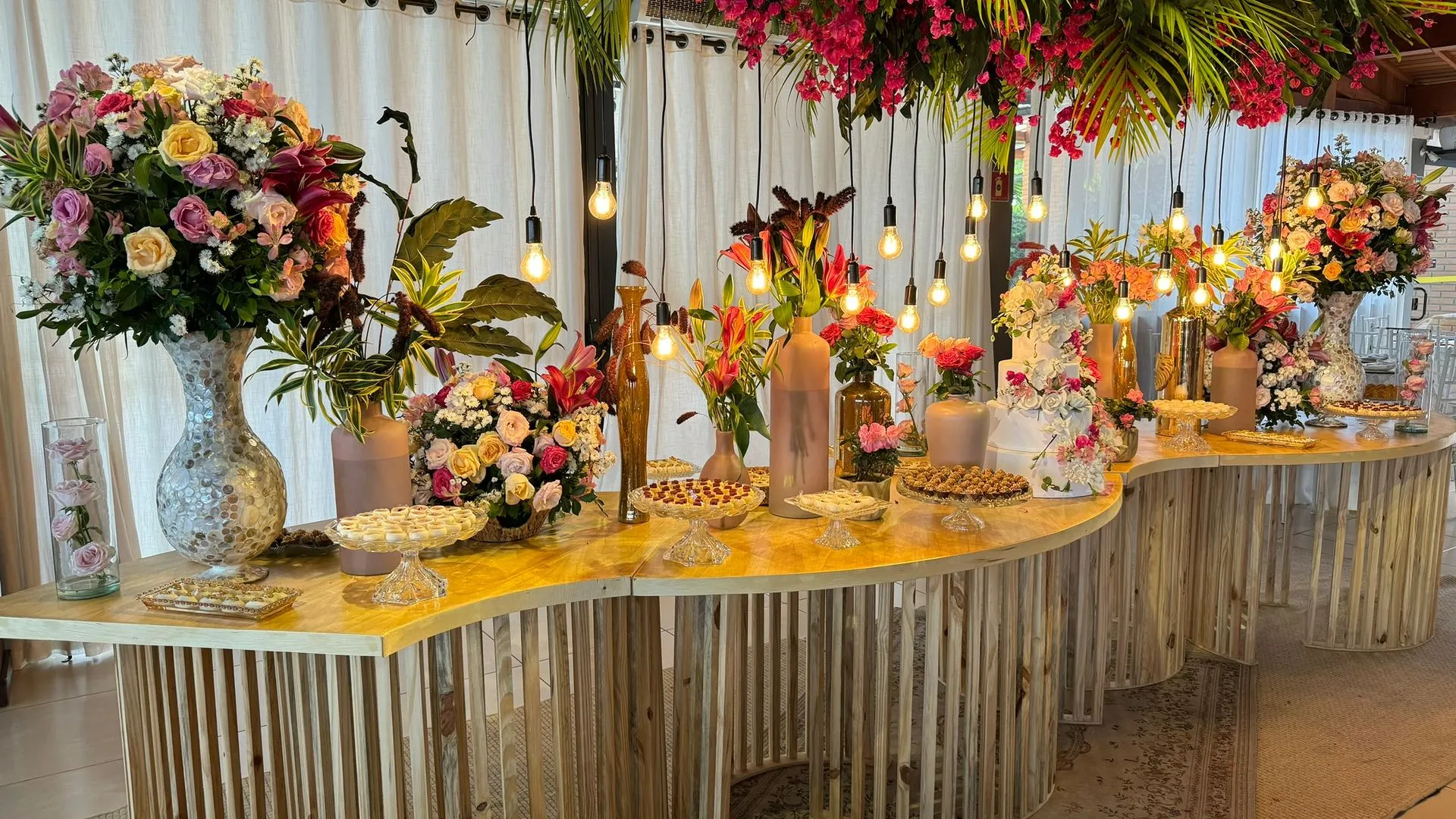 Uma mesa decorada com flores e velas para uma recepção de casamento.