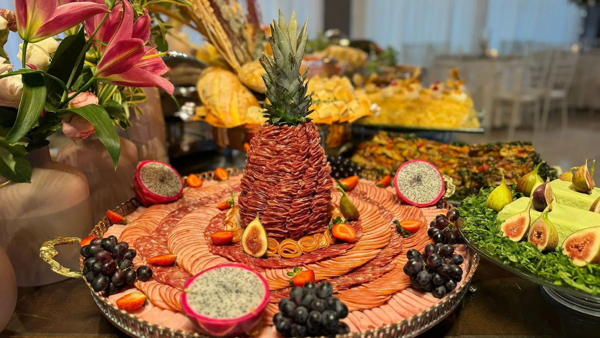 Uma mesa de bufê com um abacaxi em cima de um prato de comida.