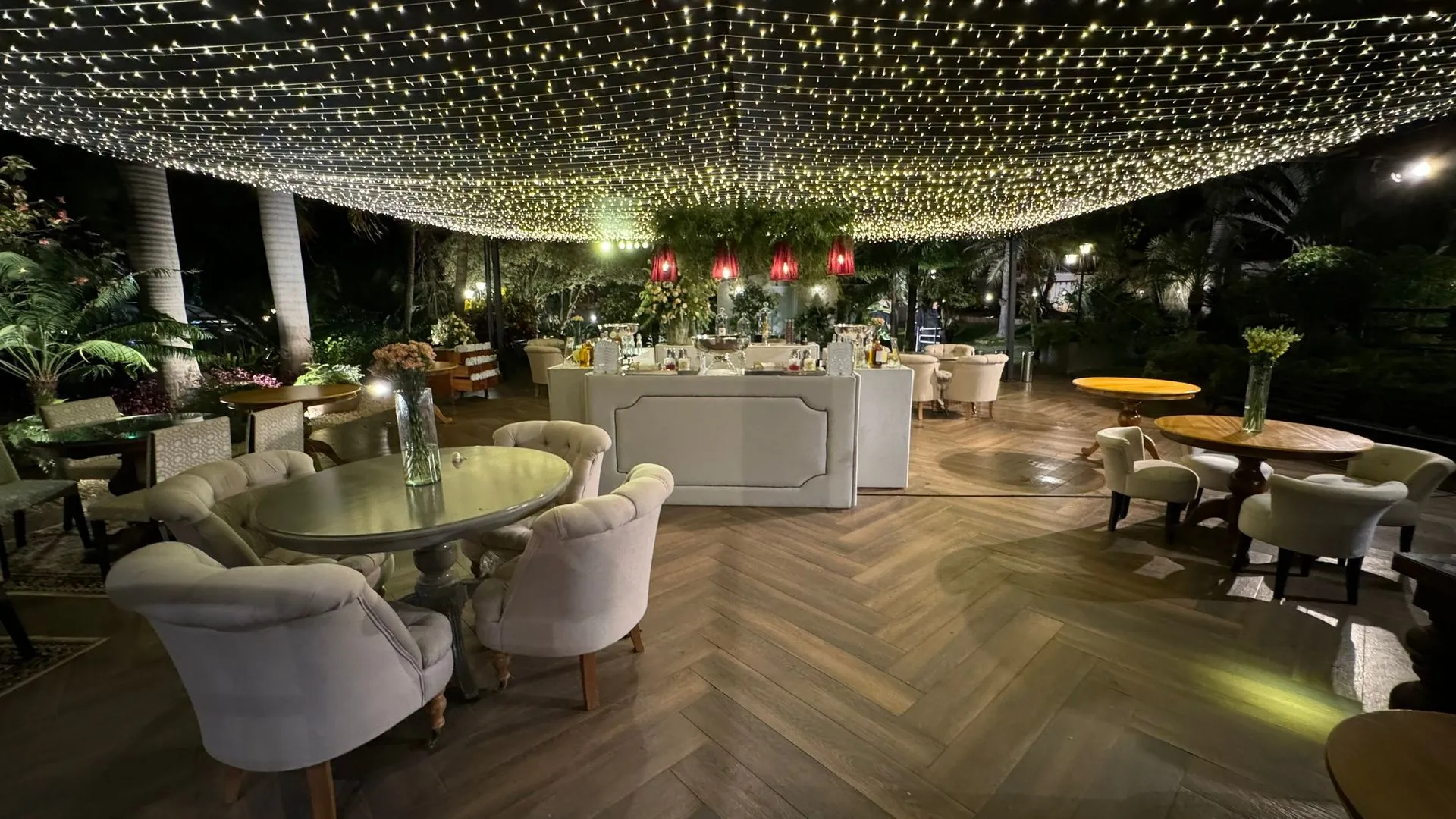 Uma grande sala com mesas e cadeiras e um teto coberto de luzes.