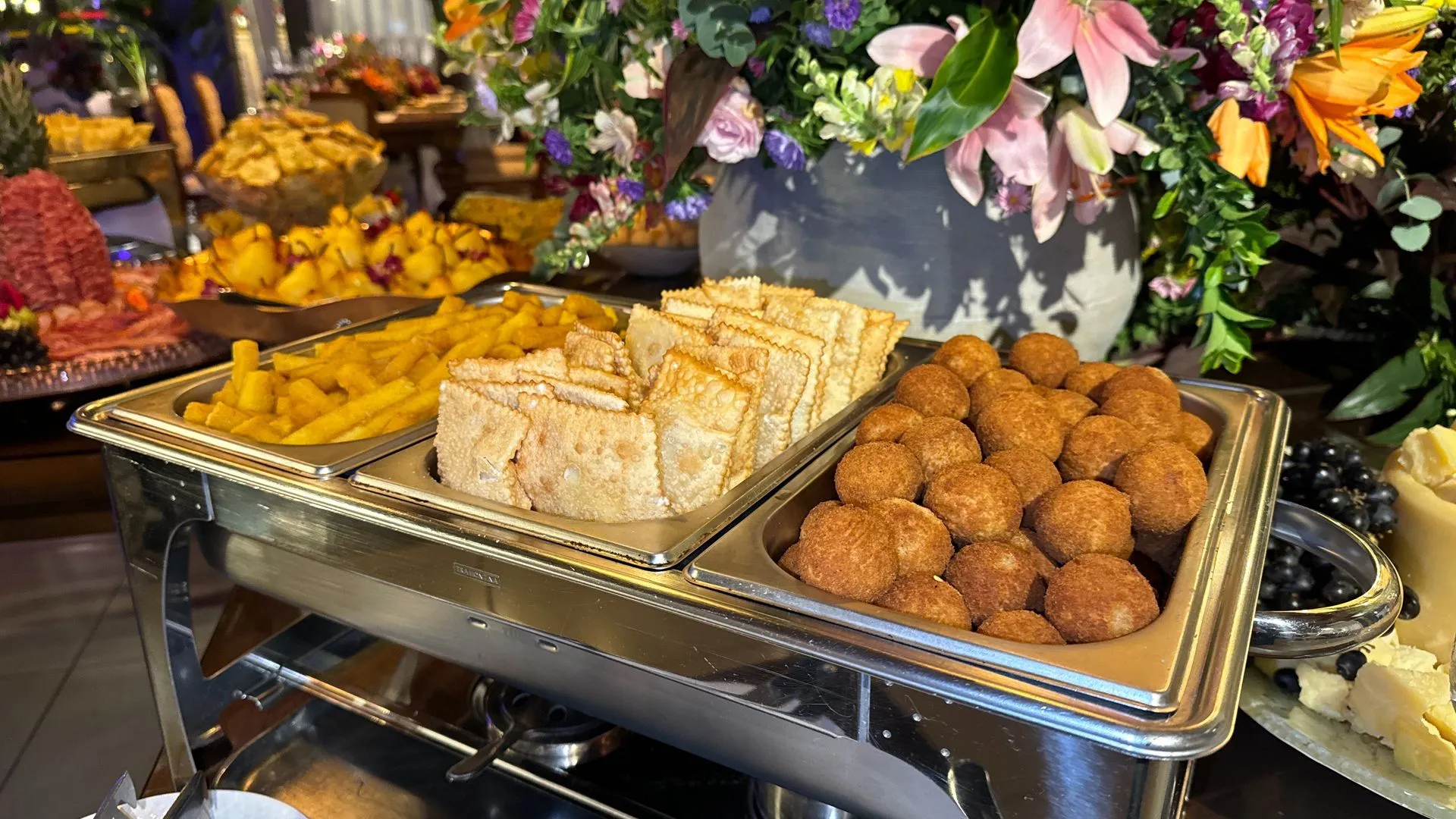 Uma mesa de buffet com uma variedade de comida e flores.
