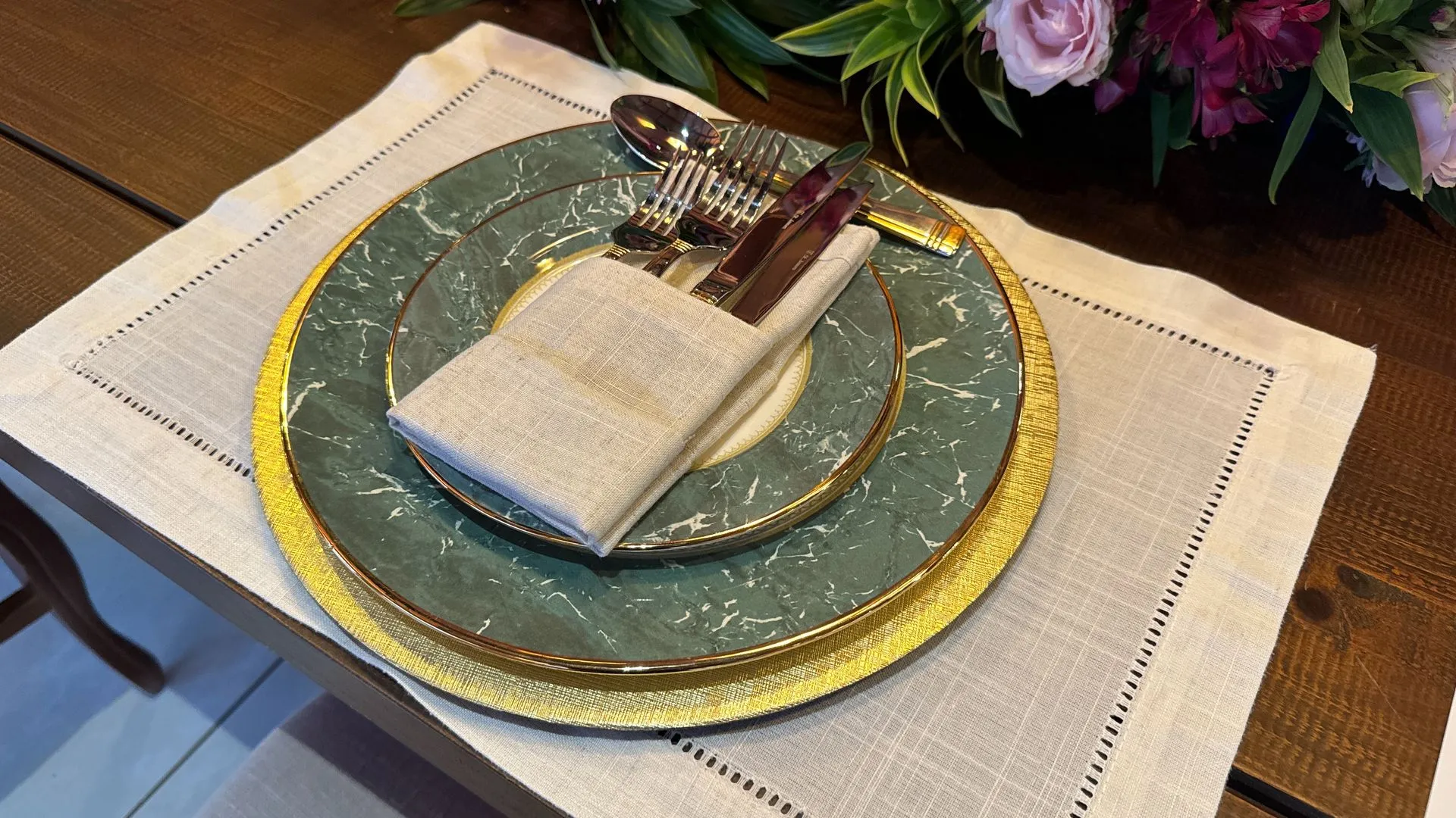 Um talheres com pratos, utensílios e um guardanapo sobre uma mesa.